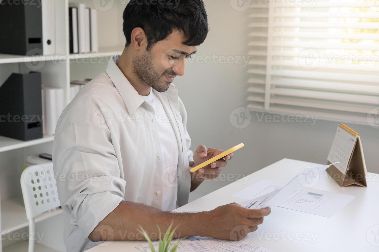 business men use phone to scan barcode or QR codes to pay credit card bill after receiving document invoice online. payment, receive, paying electricity, digital payments without money, technology photo