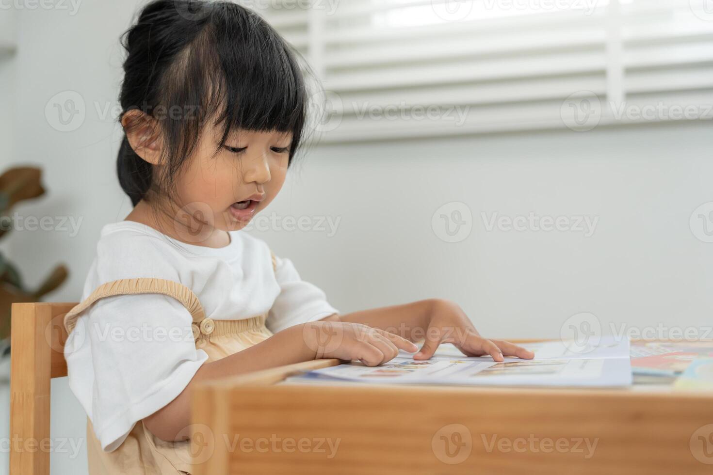 Happy Asian child relax read book at home. daughter and reading a story. learn development, childcare, laughing, education, storytelling, practice, imagine, reduce addiction mobile phone photo
