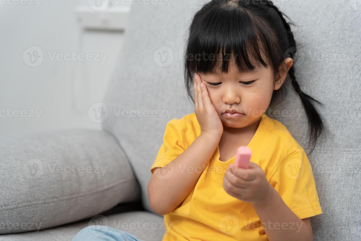 presses hand to cheek after eat sweet, suffers from pain in tooth. Teeth decay, dental problems, child emotions and facial expression, oral health care, fluorine coating, reduce sweets photo