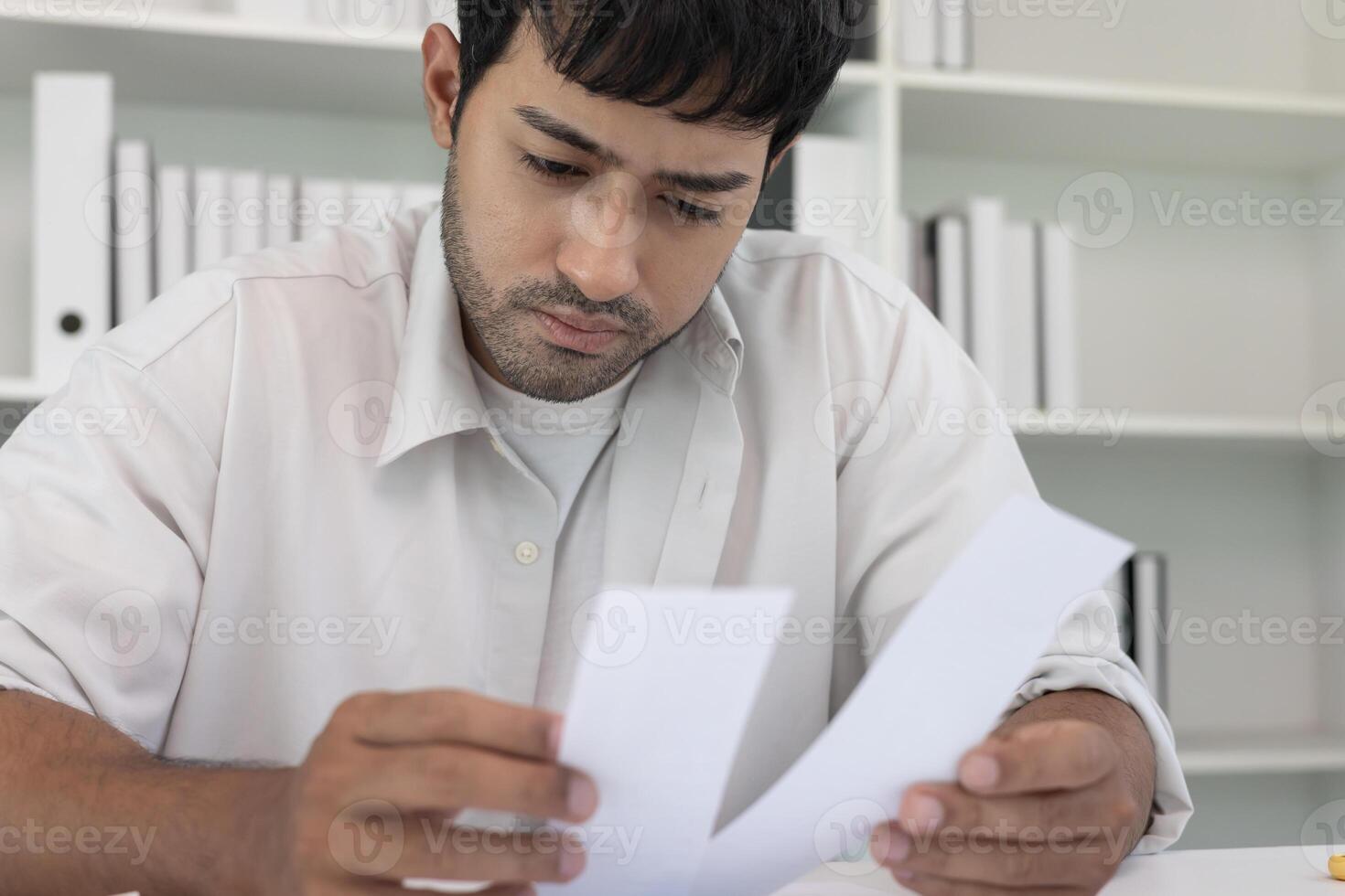 Stressed asian man with large bills or invoices no money to pay to expenses and credit card debt. shortage, Financial problems, mortgage, loan, bankruptcy, bankrupt, poor, empty wallet photo