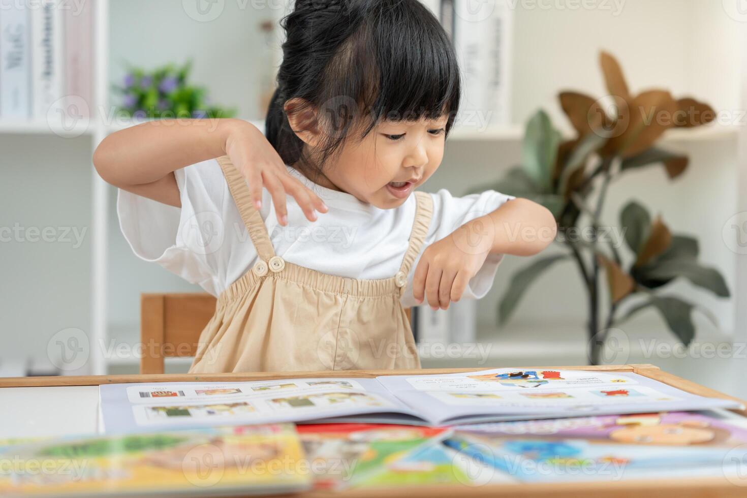 Happy Asian children relax read book at home. daughter and reading a story. learn development, childcare, laughing, education, storytelling, practice, imagine, reduce addiction phone photo