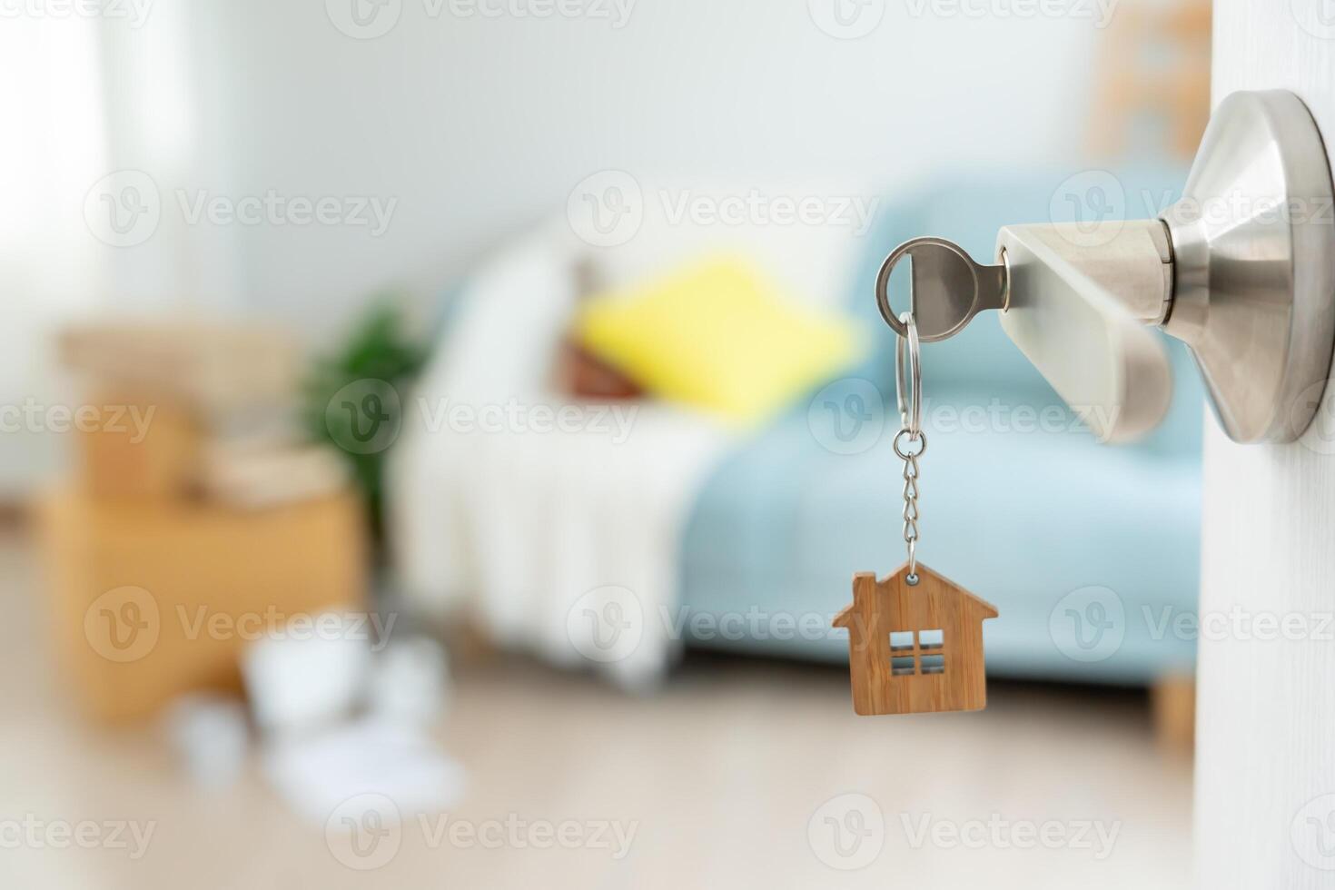 key was inserted into the door of the new house, inside the room was a cardboard box containing personal belongings and furniture. move in the apartment or condominium photo