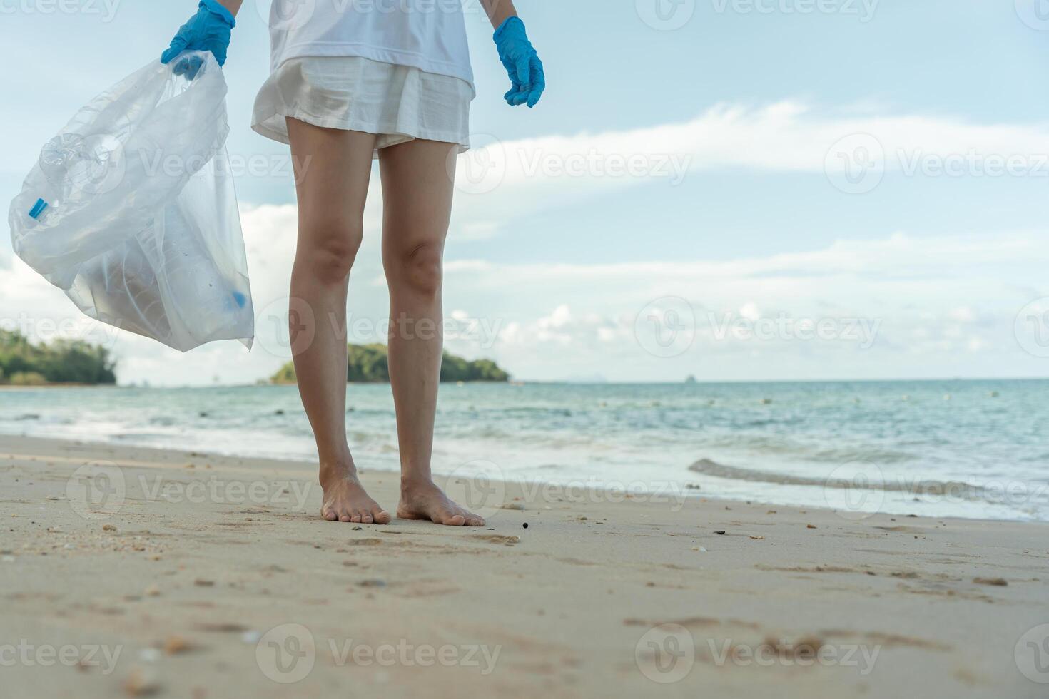 pick up trash garbage at the beach and plastic bottles are difficult decompose prevent harm aquatic life. Earth, Environment, Greening planet, reduce global warming, Save world photo