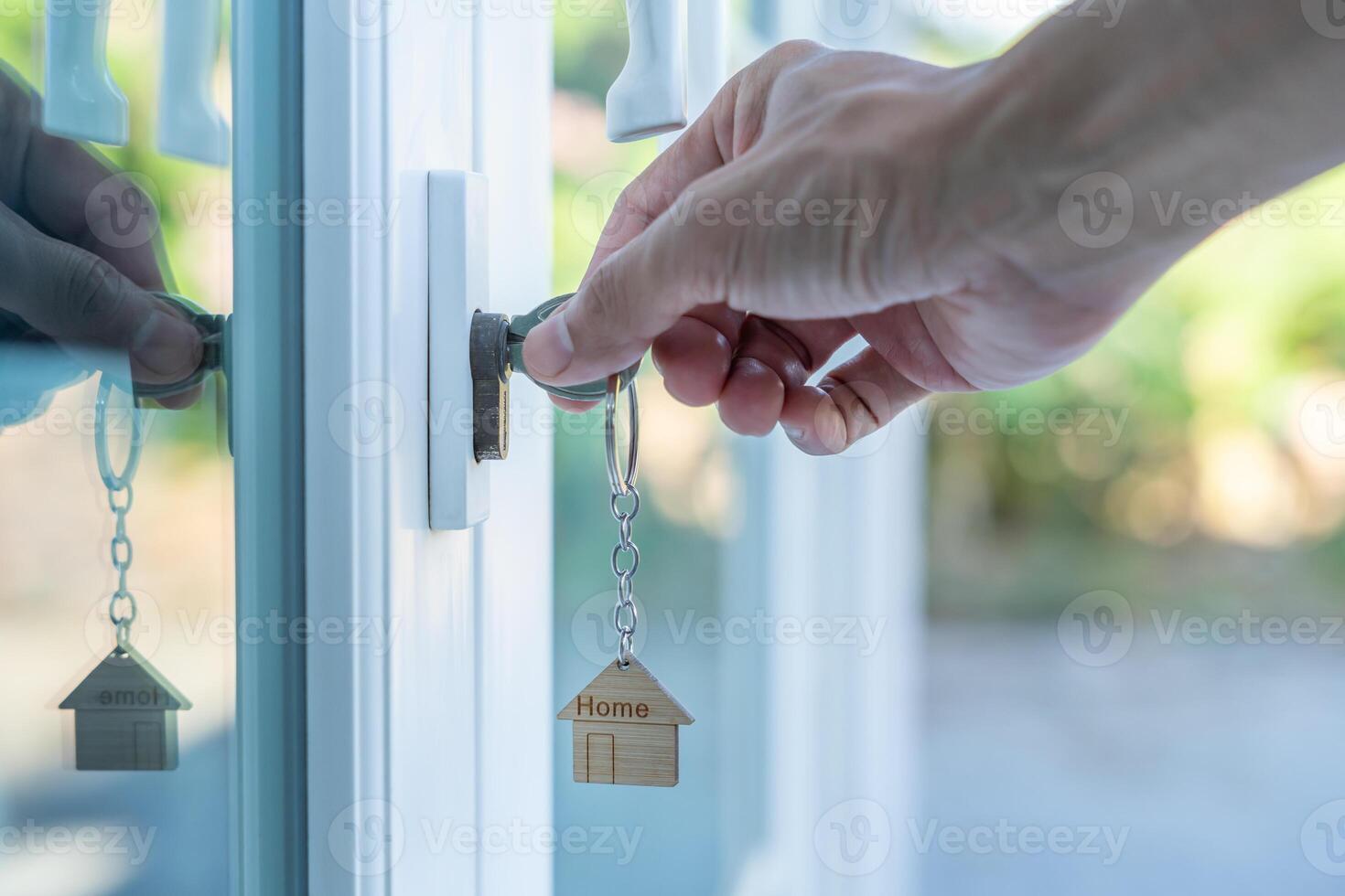 Landlord key for unlocking house is plugged into the door. Second hand house for rent and sale. Owner use hand unlock door mortgage for new home, buy, sell, renovate, investment owner, estate photo
