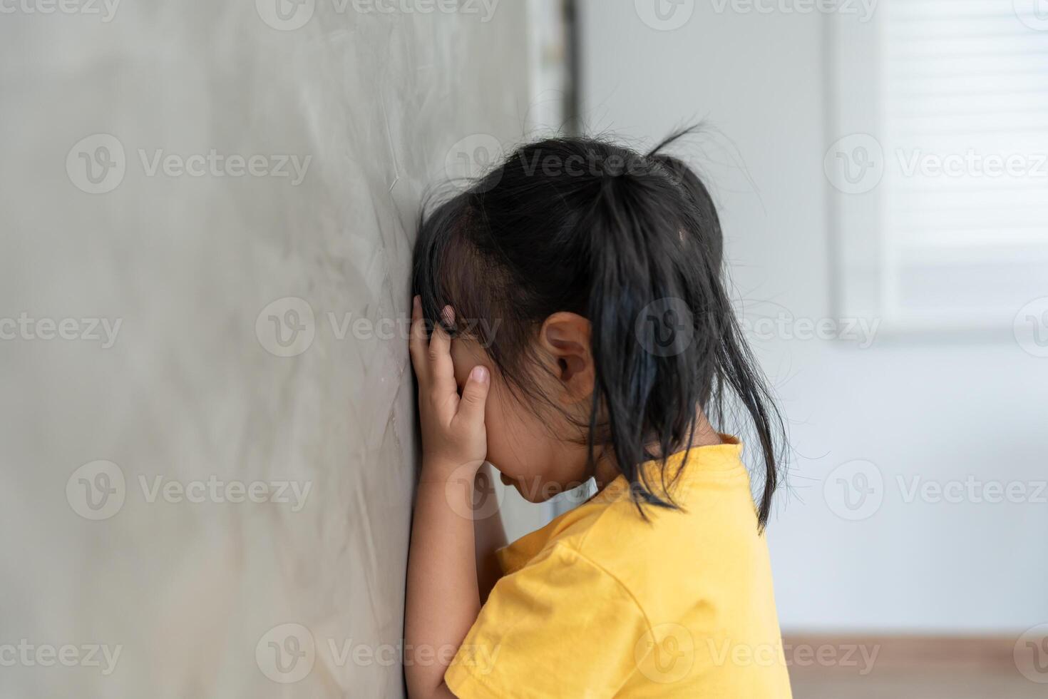 children kid girl covering his eyes with hands, playing hide and seek standing next a wall house, Adorable child having fun in the home. happy family have fun with kids, activity, learning photo