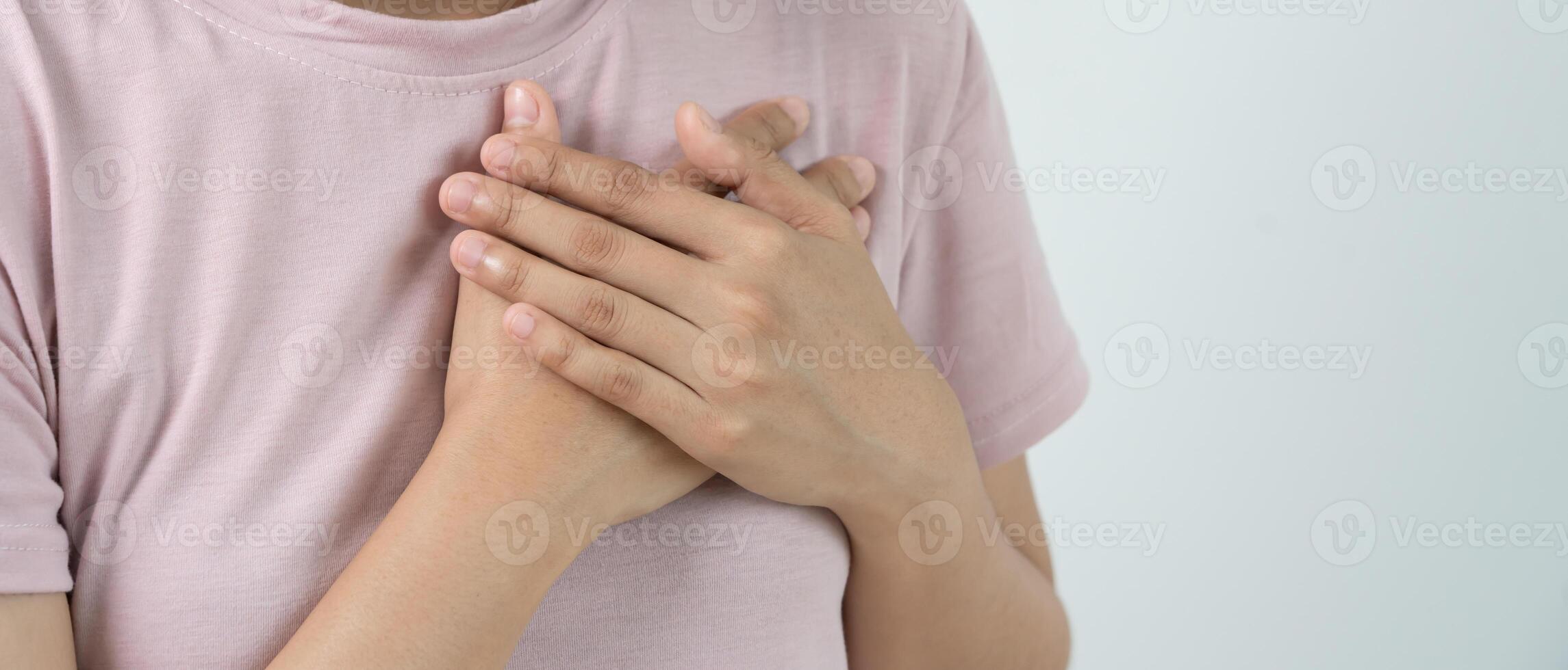 hand hold chest with heart attack symptom, asian woman have chest pain caused by heart disease, leak, dilatation, enlarged coronary heart, press on the chest with a painful expression photo