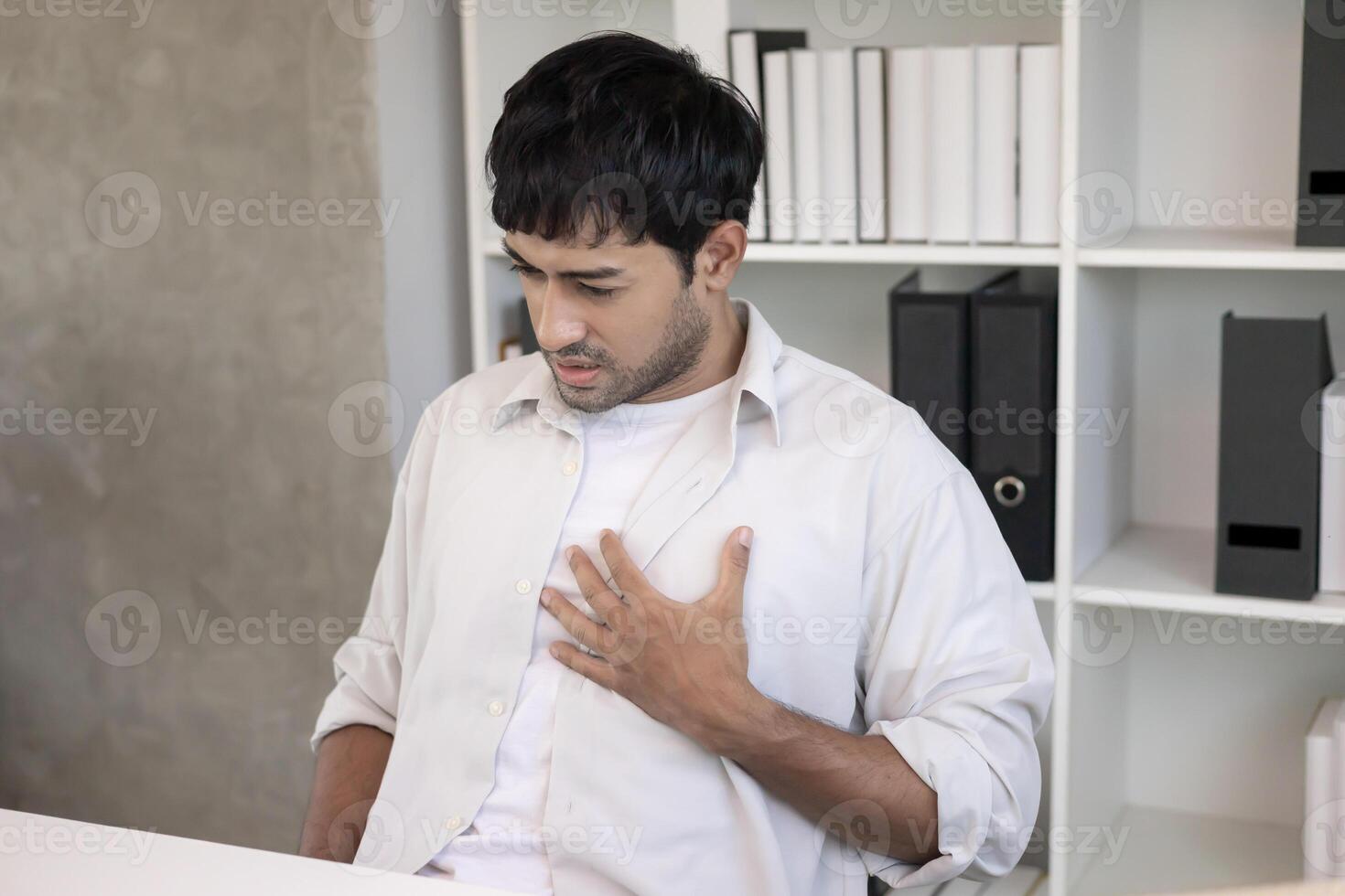 hold chest with heart attack symptoms, asian man have chest pain caused by heart disease, leak, dilatation, enlarged coronary heart, press on the chest with a painful expression photo