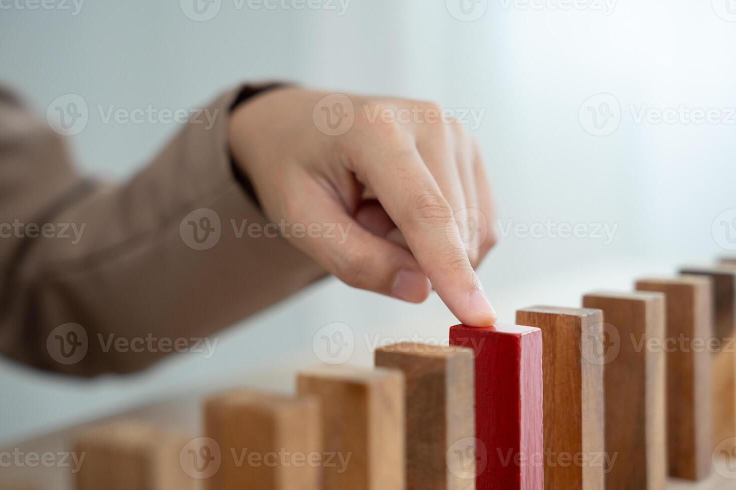 insurance with hand protect domino. Businessman hands stop dominoes falling in business crisis. business risk control and planning and strategies to run prevent insurance businesses. photo