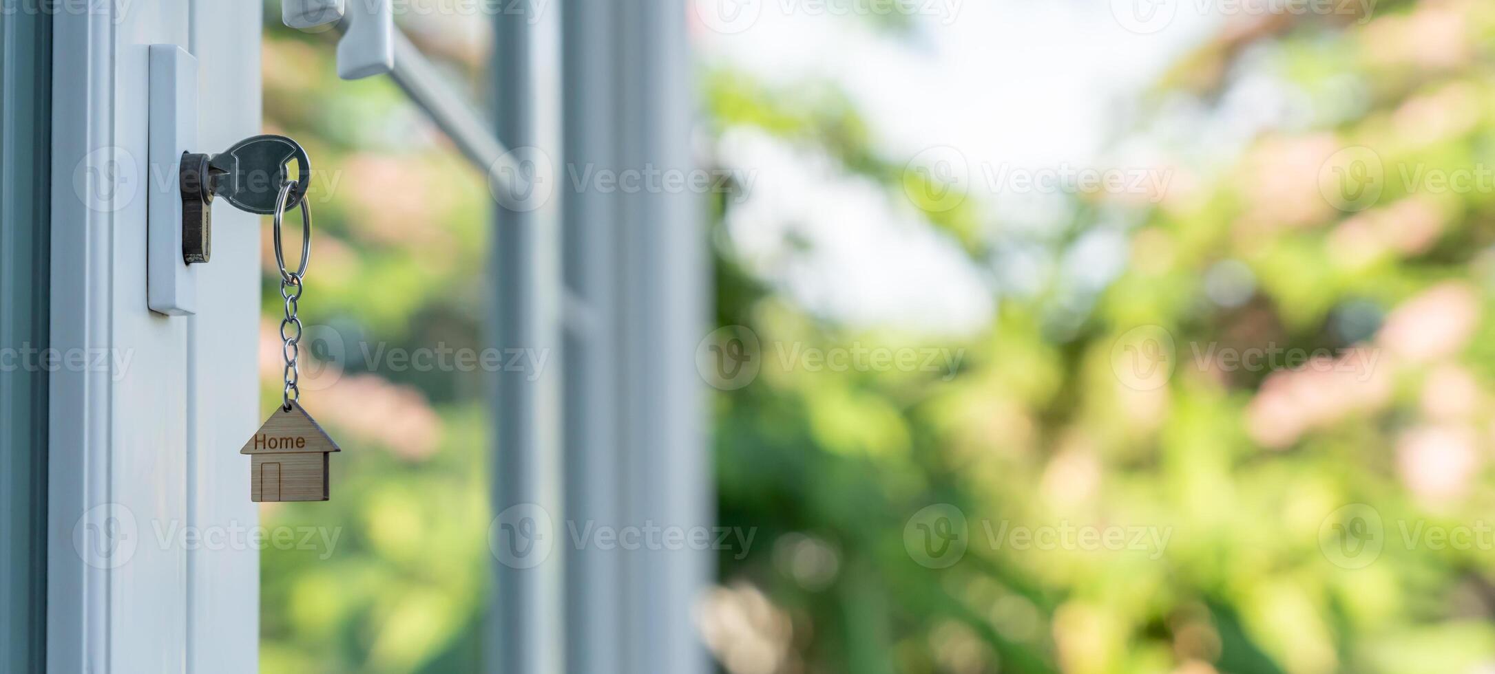 key for unlocking house is plugged into the door. Second hand house for rent and sale. keychain is blowing in the wind. mortgage for new home, buy, sell, renovate, investment, owner, photo