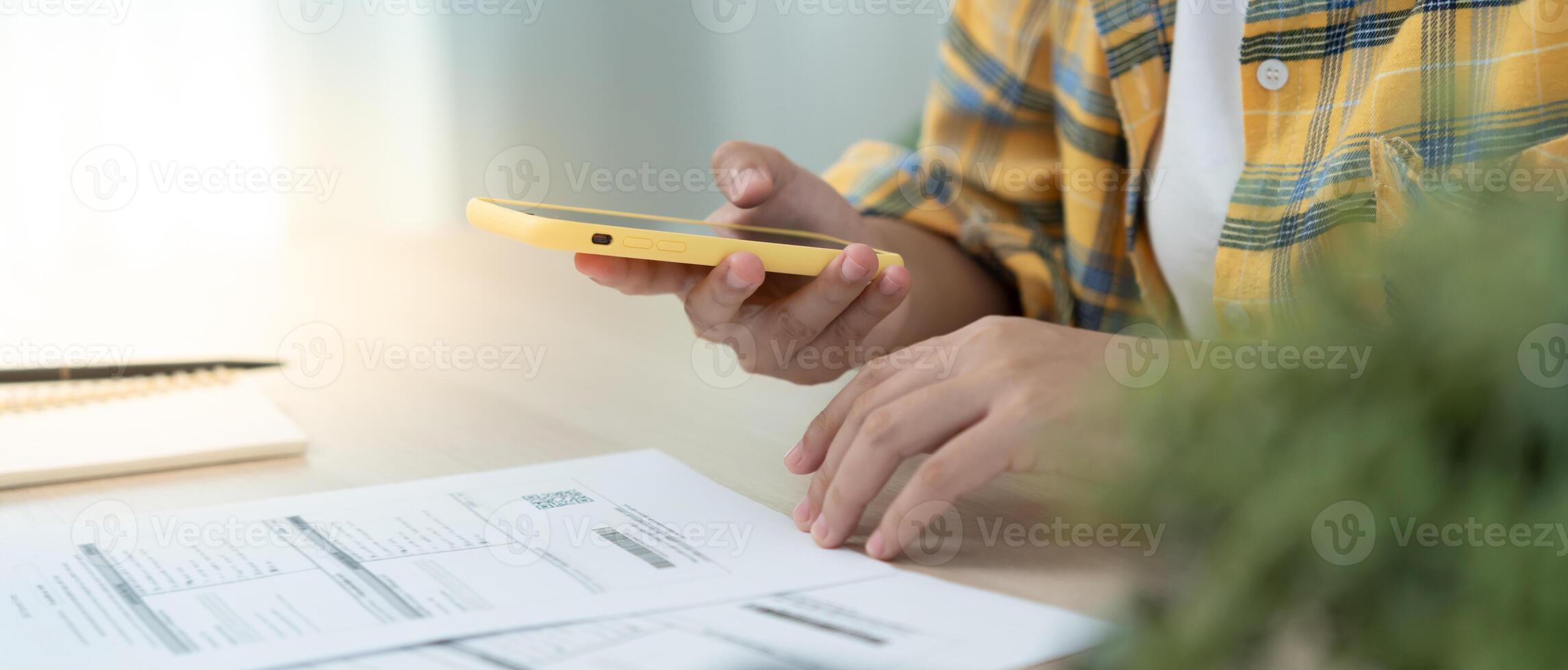 woman use phone to scan barcode or QR codes to pay credit card bill after receiving document invoice online. payment, receive, paying electricity, digital payments, technology, scanning photo