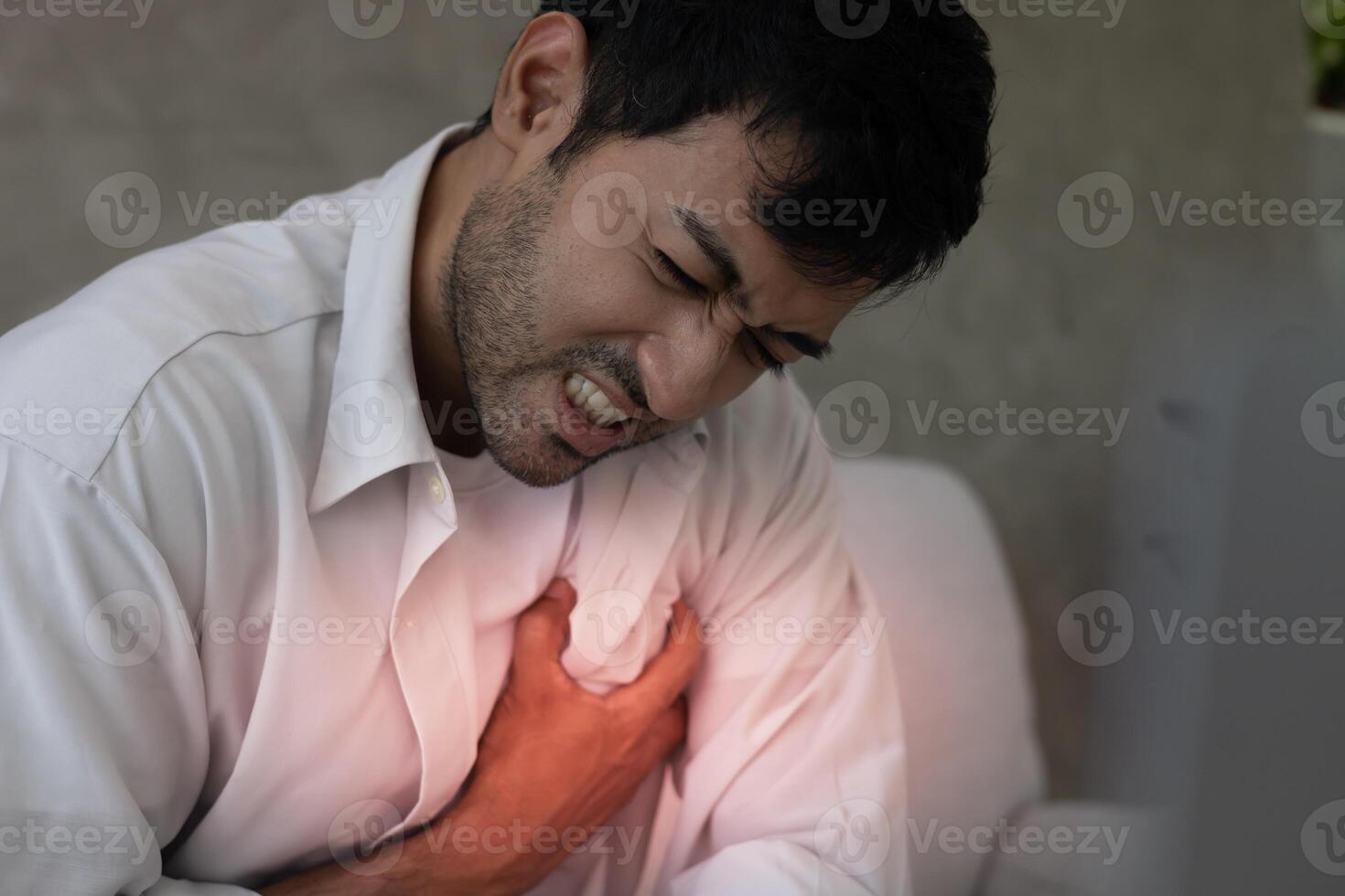 hand hold chest with heart attack symptoms, man have chest pain caused by heart disease, leak, dilatation, enlarged coronary heart, press on the chest with a painful expression photo