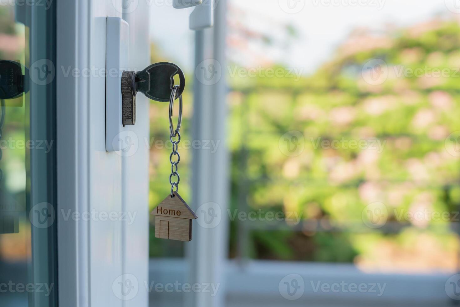key for unlocking house is plugged into the door. Second hand house for rent and sale. keychain is blowing in the wind. mortgage for new home, buy, sell, renovate, investment, owner photo