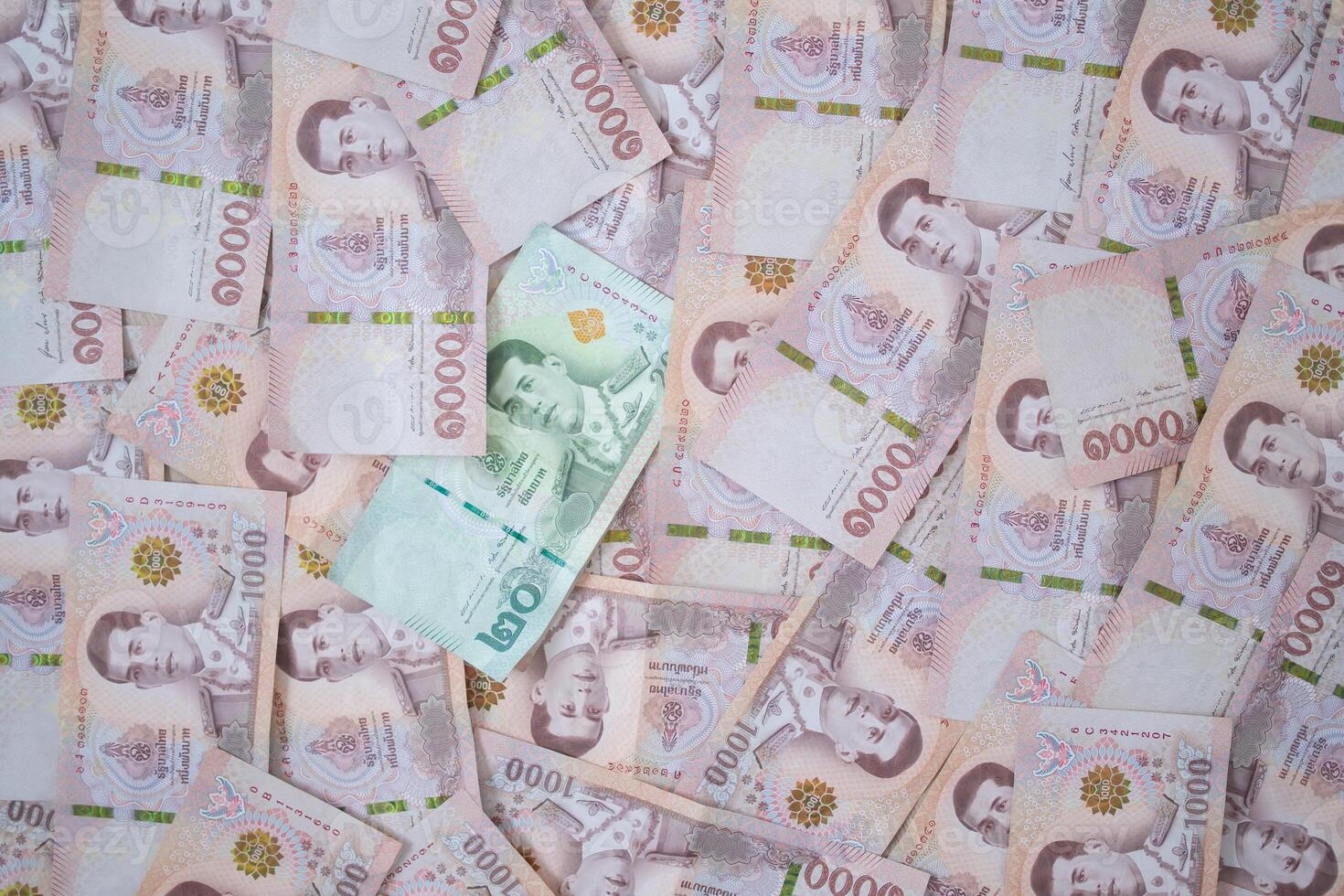 Many THAI bank notes Placed on the table.The Baht is the currency of Thailand that is used to change, buy, sell, accumulate, and invest in Thailand stock. photo