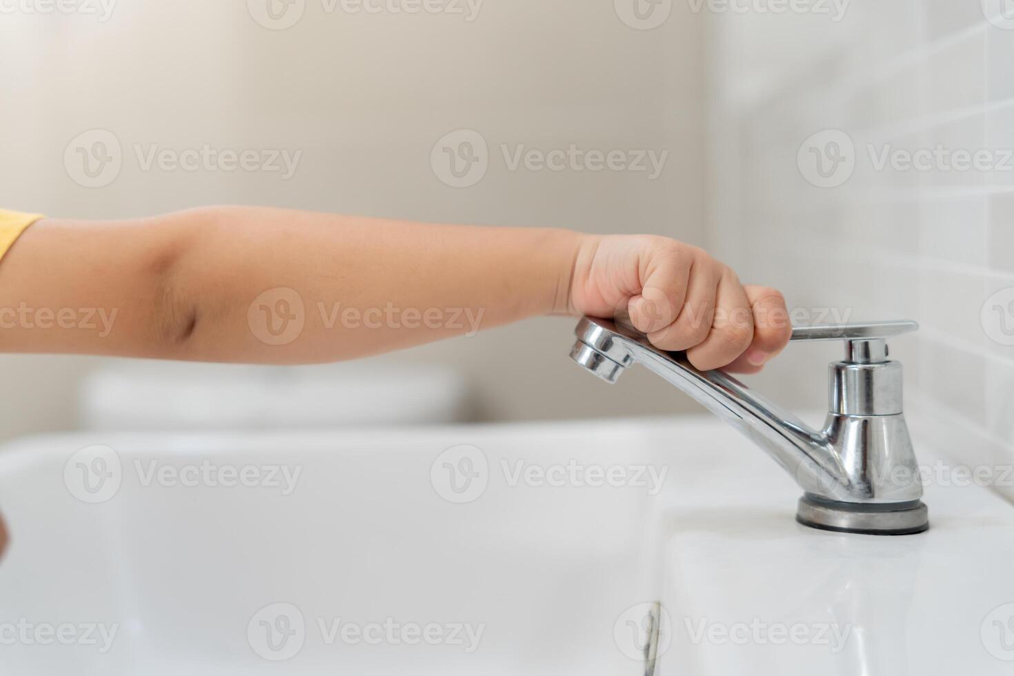 Save water. kid keeps turning off the running water in the bathroom to protect environment. Greening planet, reduce global warming, Save world, life, future, risk energy, crisis , water day. photo