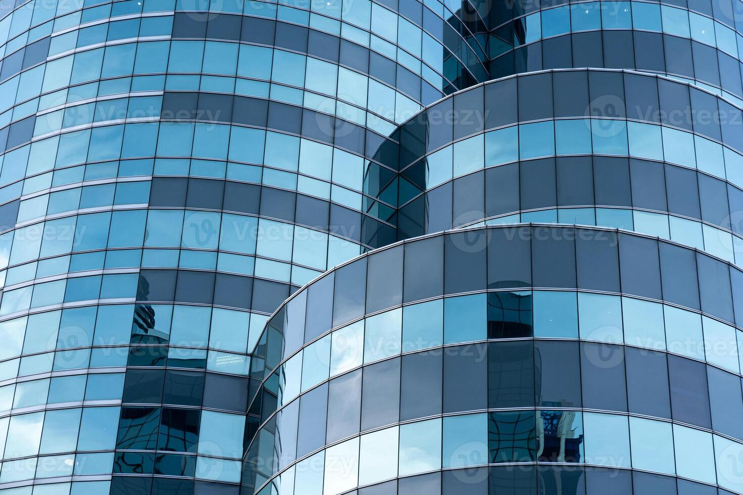 Modern Glass Architecture with Curved Reflections in Urban Skyline. Modern curved high rise building. Glass facade of skyscraper. Office building exterior. photo
