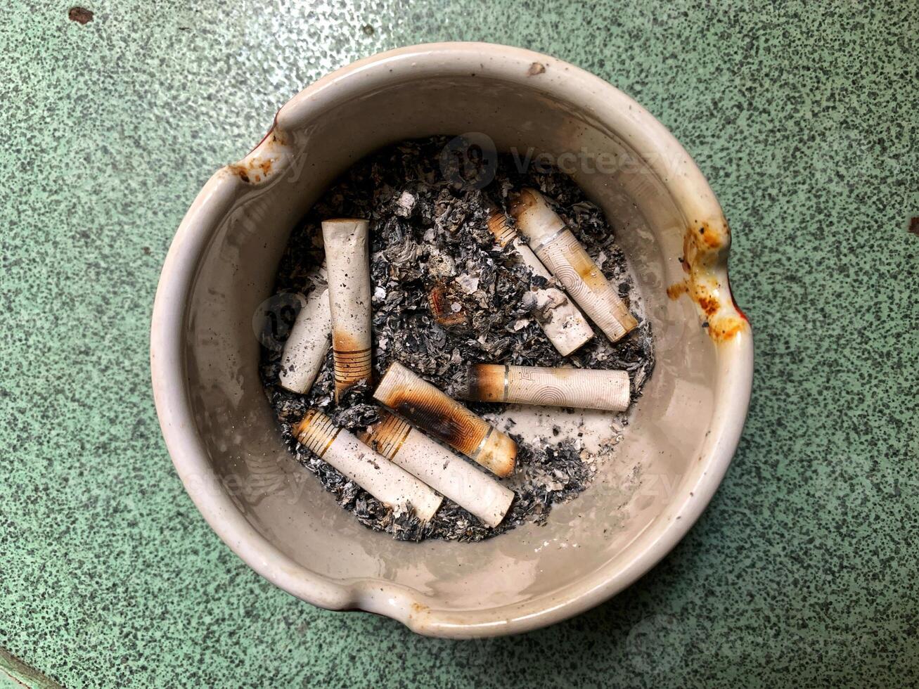 Cigarette ashtray full of cigarette ash photo