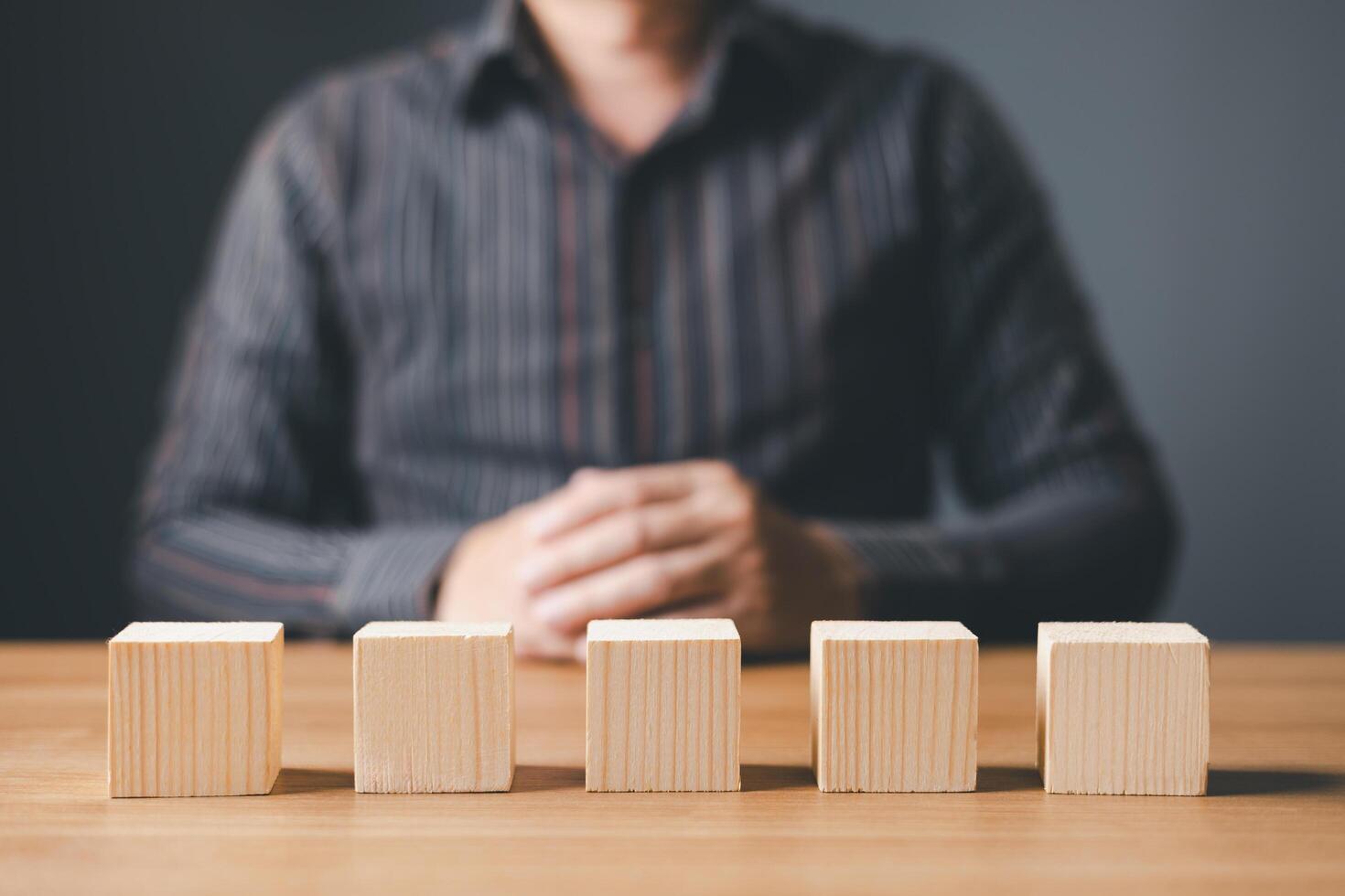 businessman sit on table and wood empty five blocks with copy space for text or symbols, development concept for growth success process. photo