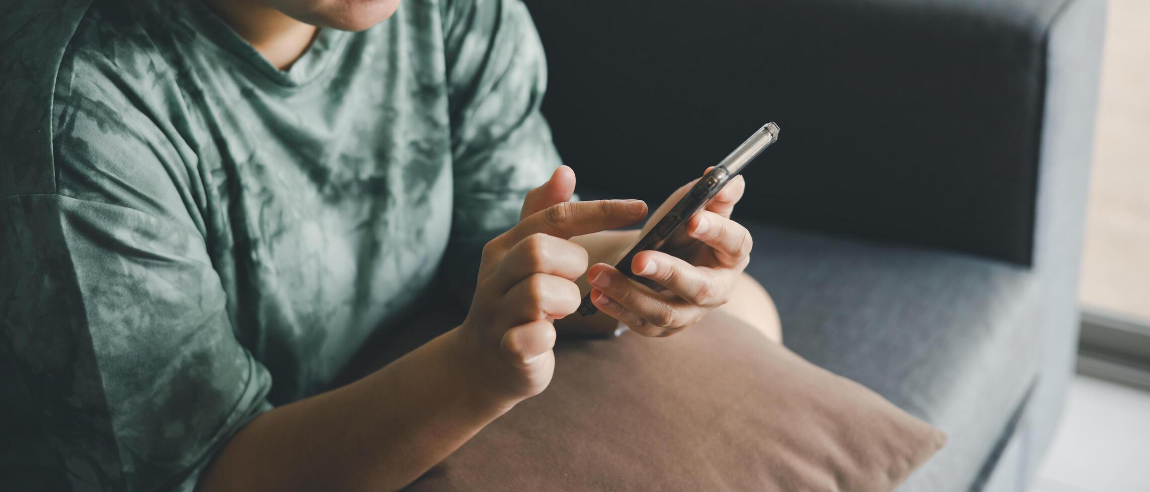 hand of asian woman using smartphone on sofa relaxing and shopping online working from anyware. use of technology. photo
