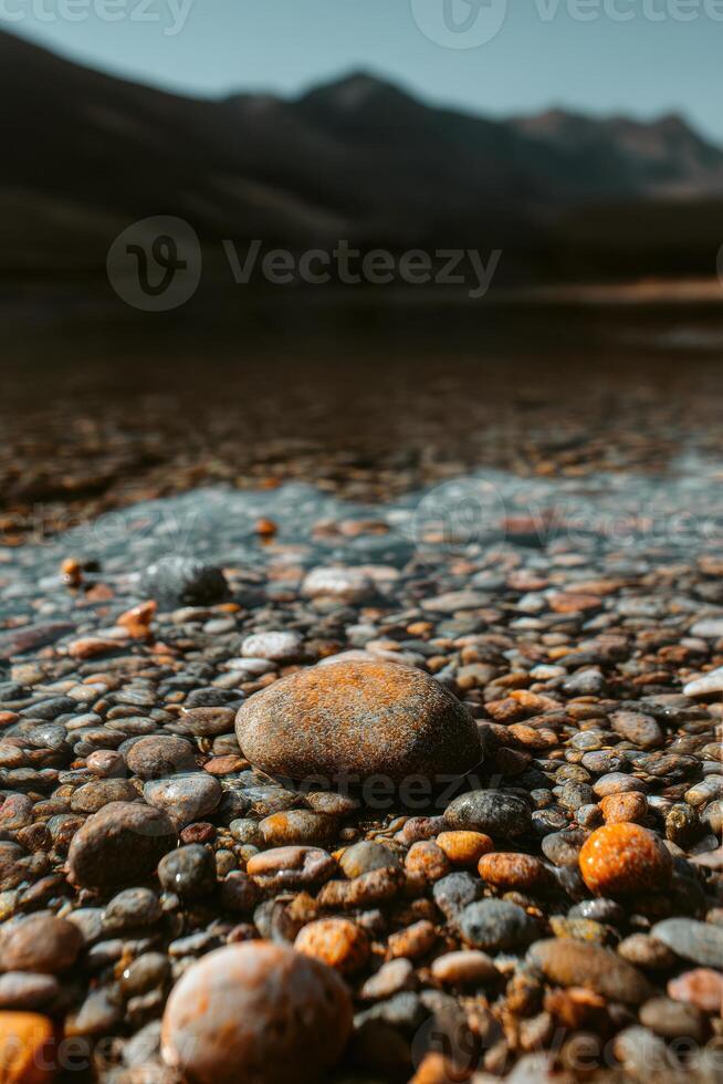 A rock is sitting in the water with a mountain in the background photo