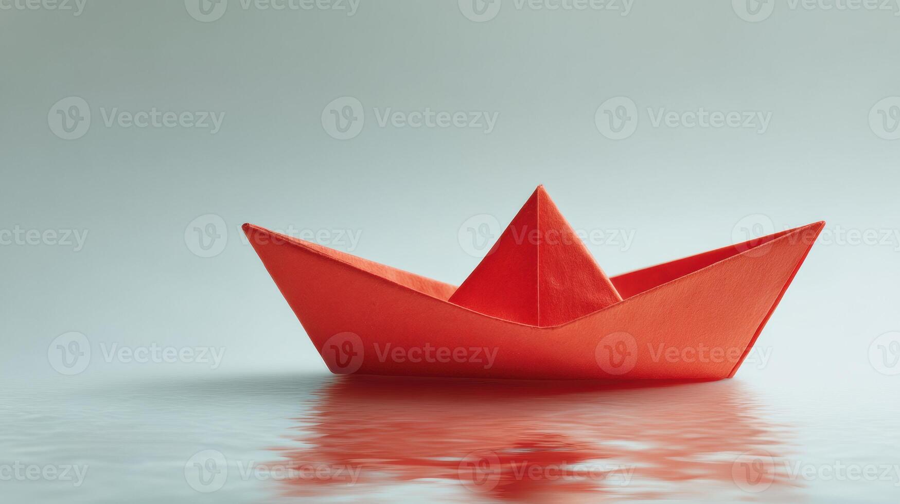 A red paper boat floating on the water photo