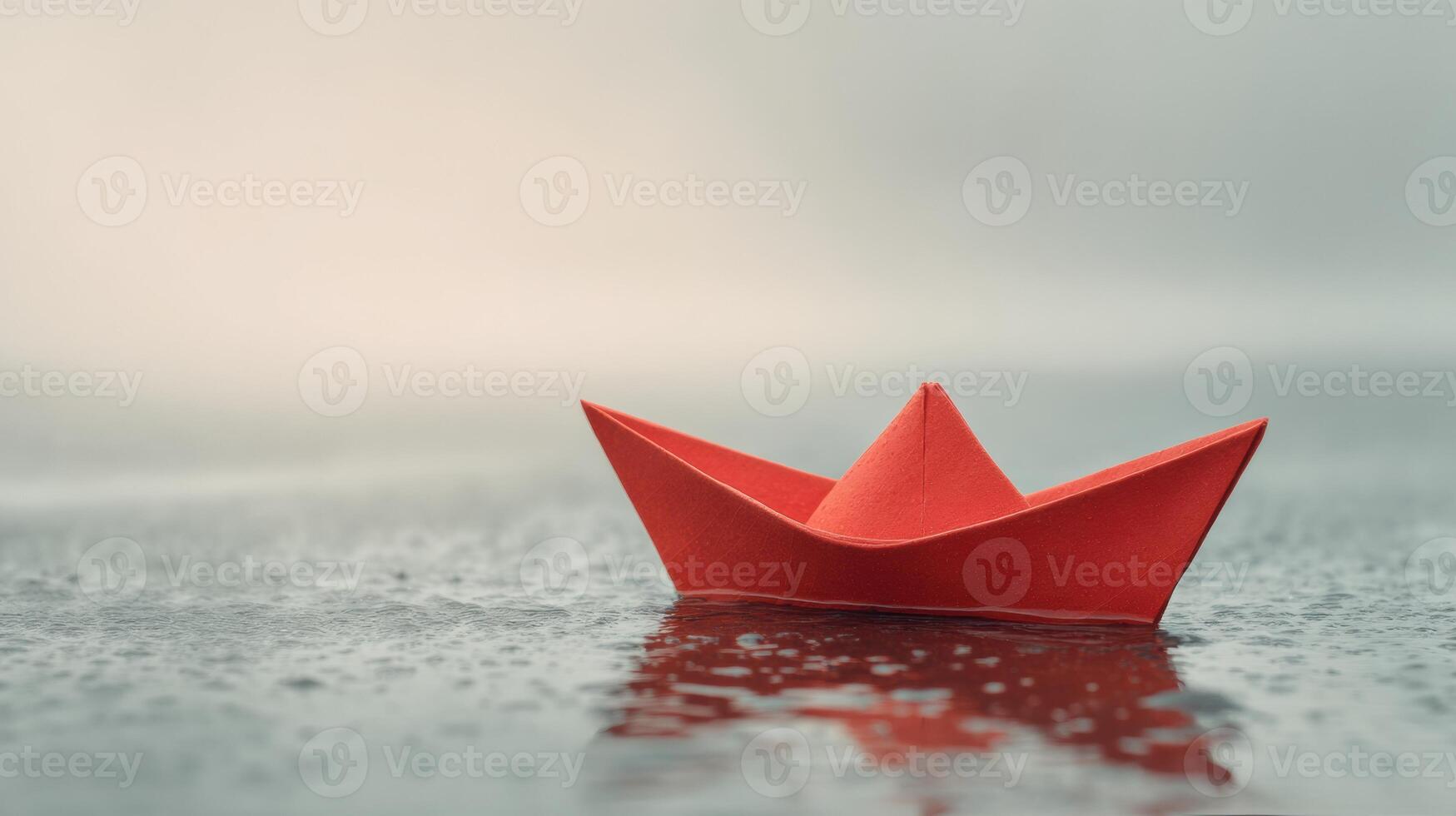 A red paper boat floating in the water photo