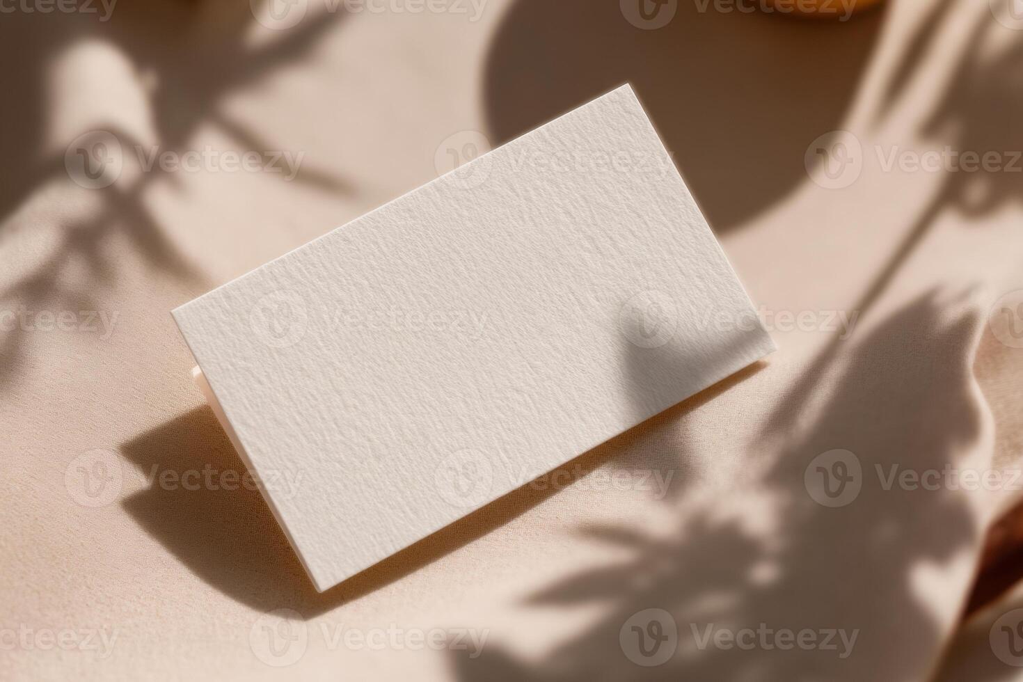 A white card on a table with oranges and leaves photo