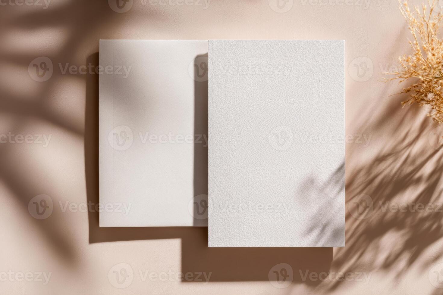 Two blank white sheets of paper on a tan background photo