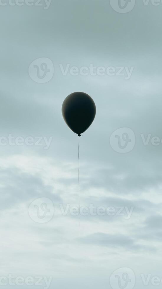 A black balloon floating in the sky photo