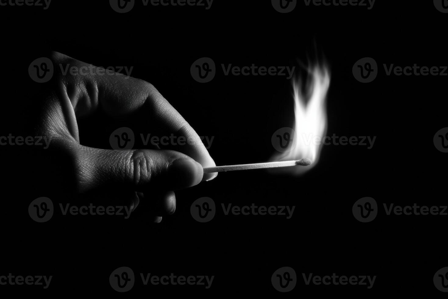 A person holding a matchstick in the dark photo