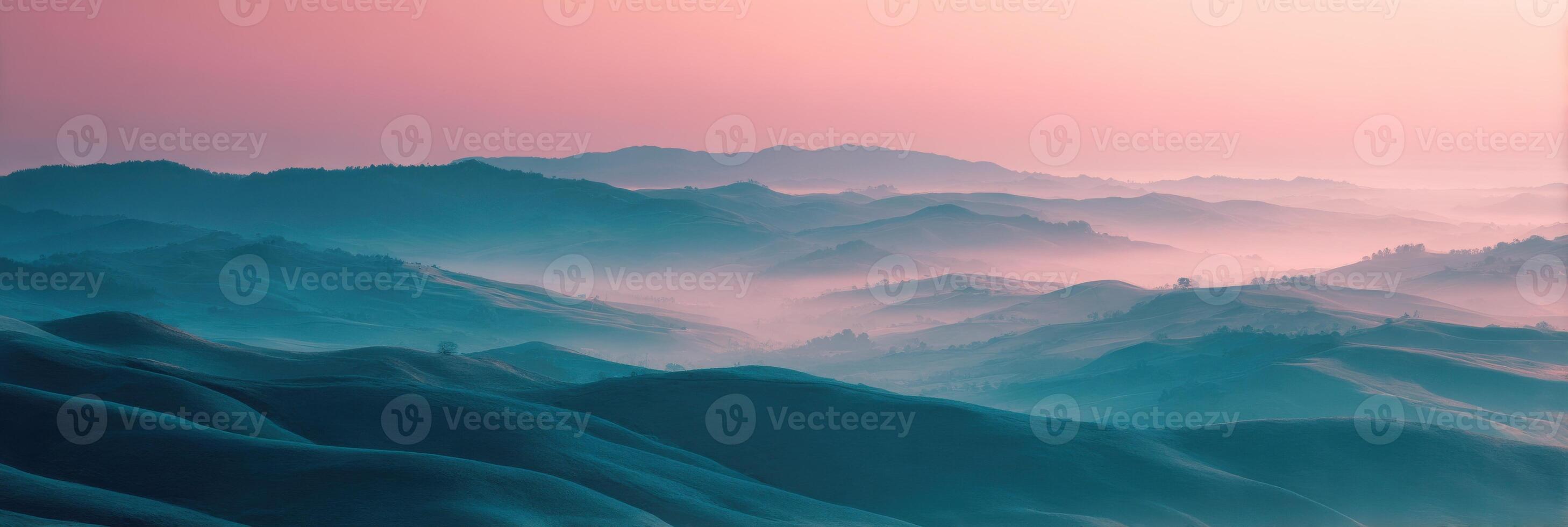 A pink sky and blue mountains in the distance photo