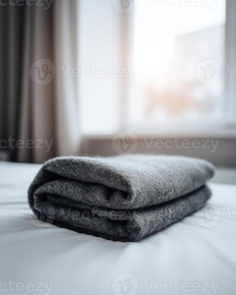A folded blanket is sitting on a bed photo
