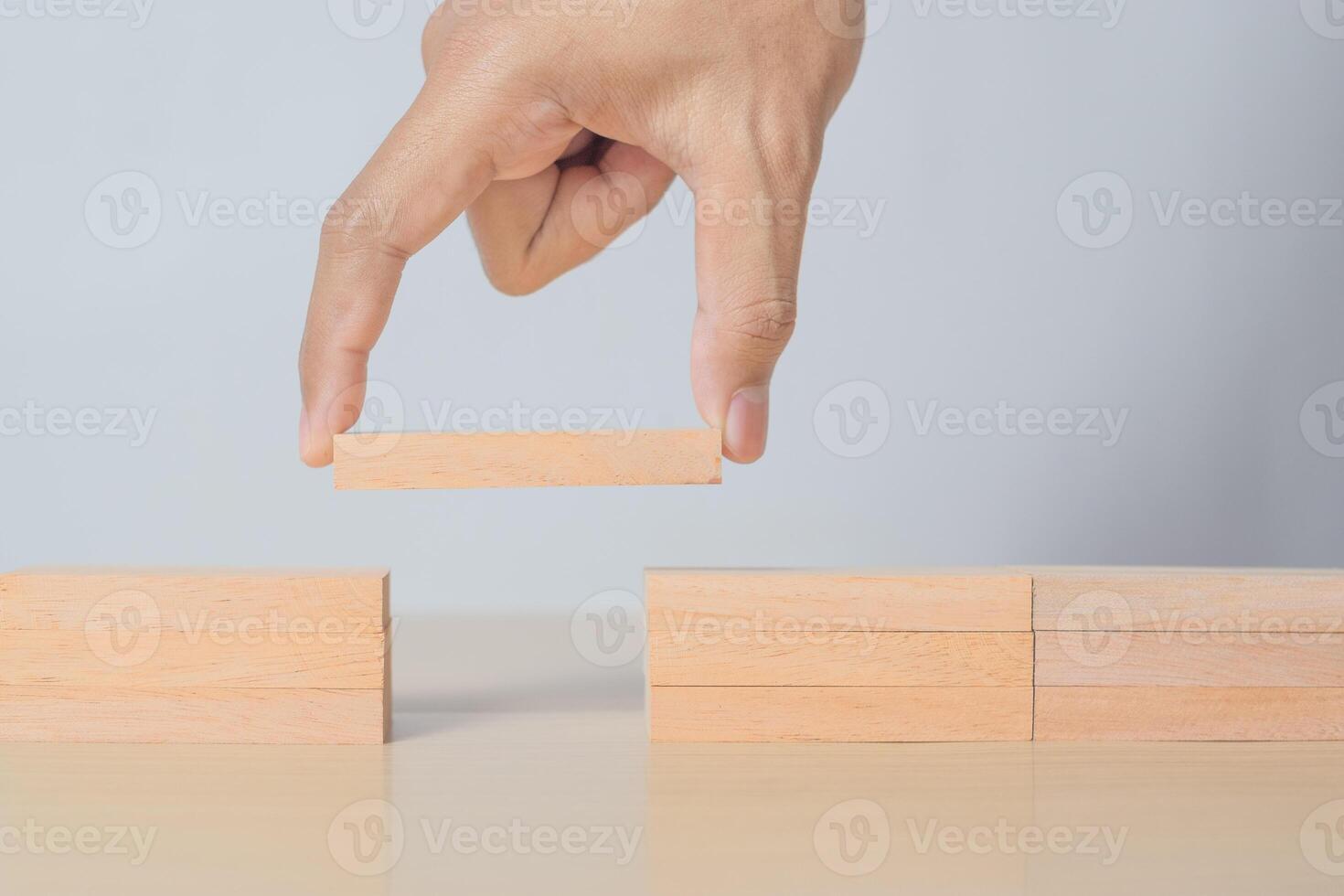 Man solving problems by building bridge with wooden block photo