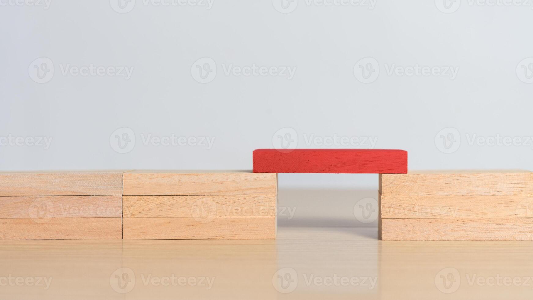 Red wooden block connecting both sides. Concept of problem solving, leadership, key contribution, and standing out by enabling connection and progress. photo