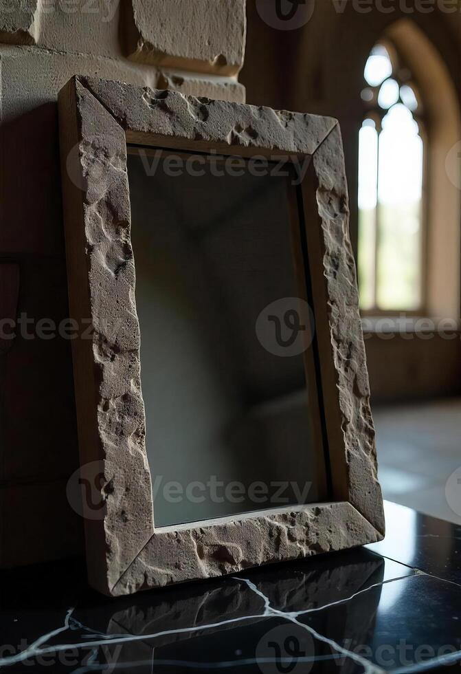 A stone framed mirror with a rough texture, reflecting a blurred room with a window, creating a vintage and artistic effect photo