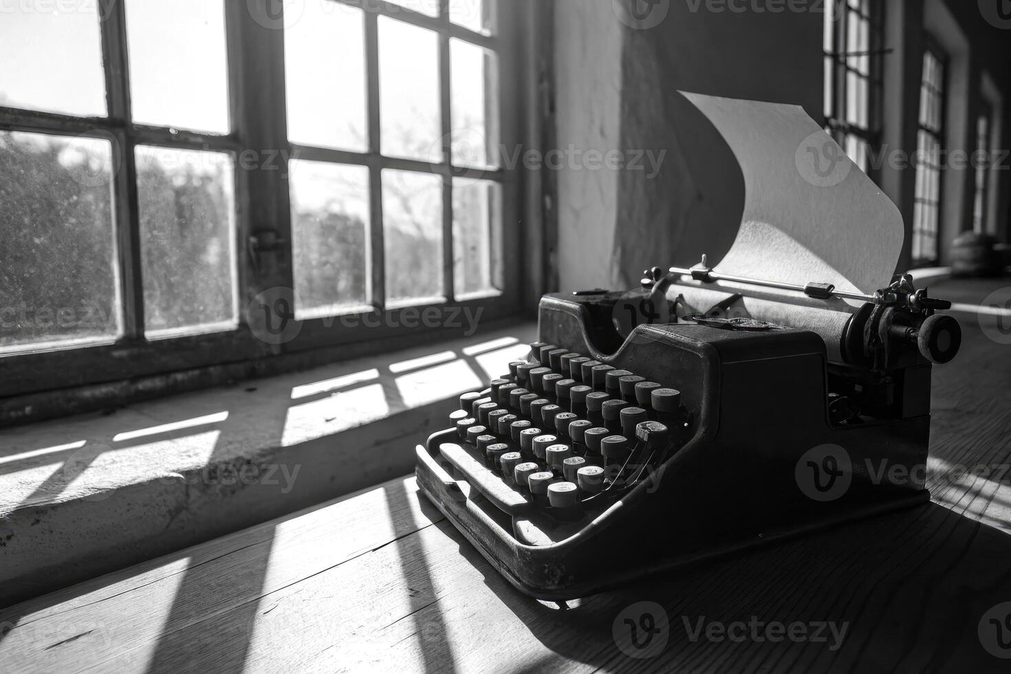A classic black and white image features a vintage typewriter by a sunlit window. photo