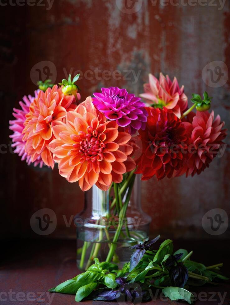 Colorful dahlia bouquet in a glass vase with fresh herbs on a rustic background photo