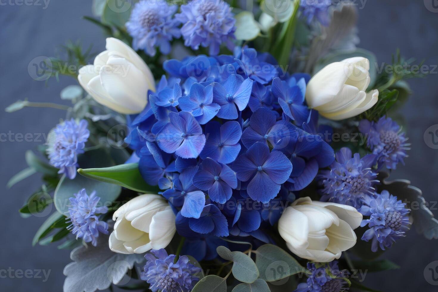 Stunning floral arrangement showcasing vibrant blue hydrangeas and elegant white tulips. photo