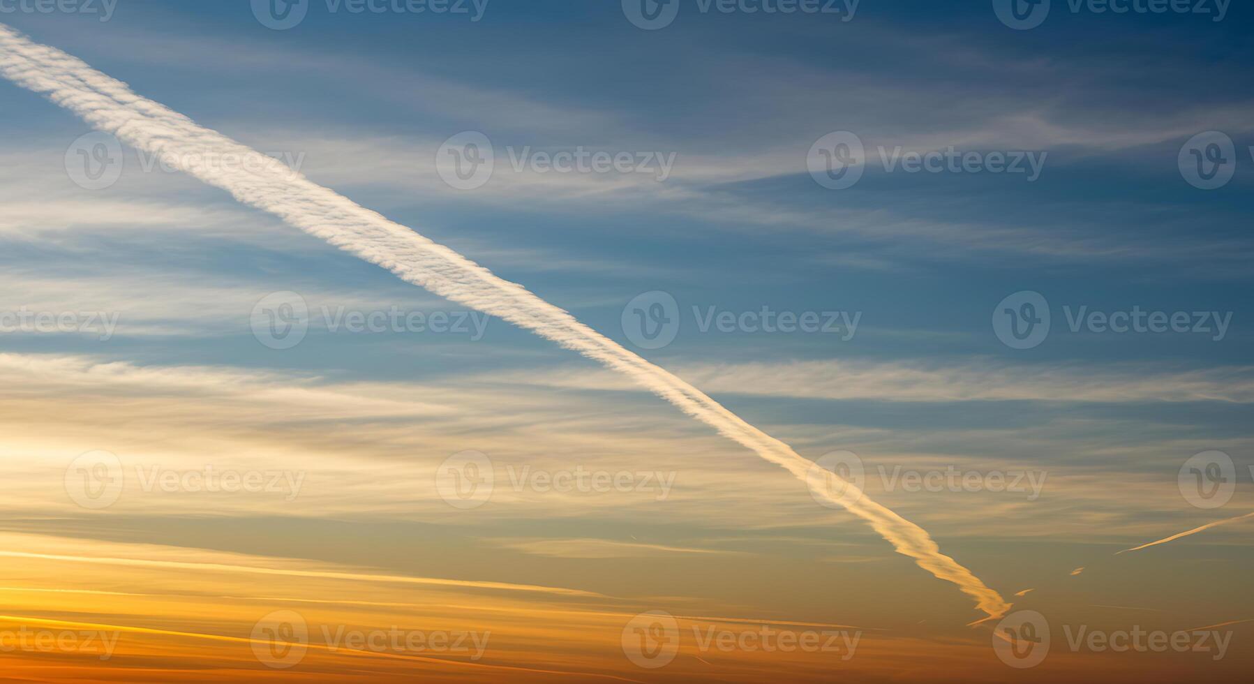 A plane flying over a blue sky with contrails photo