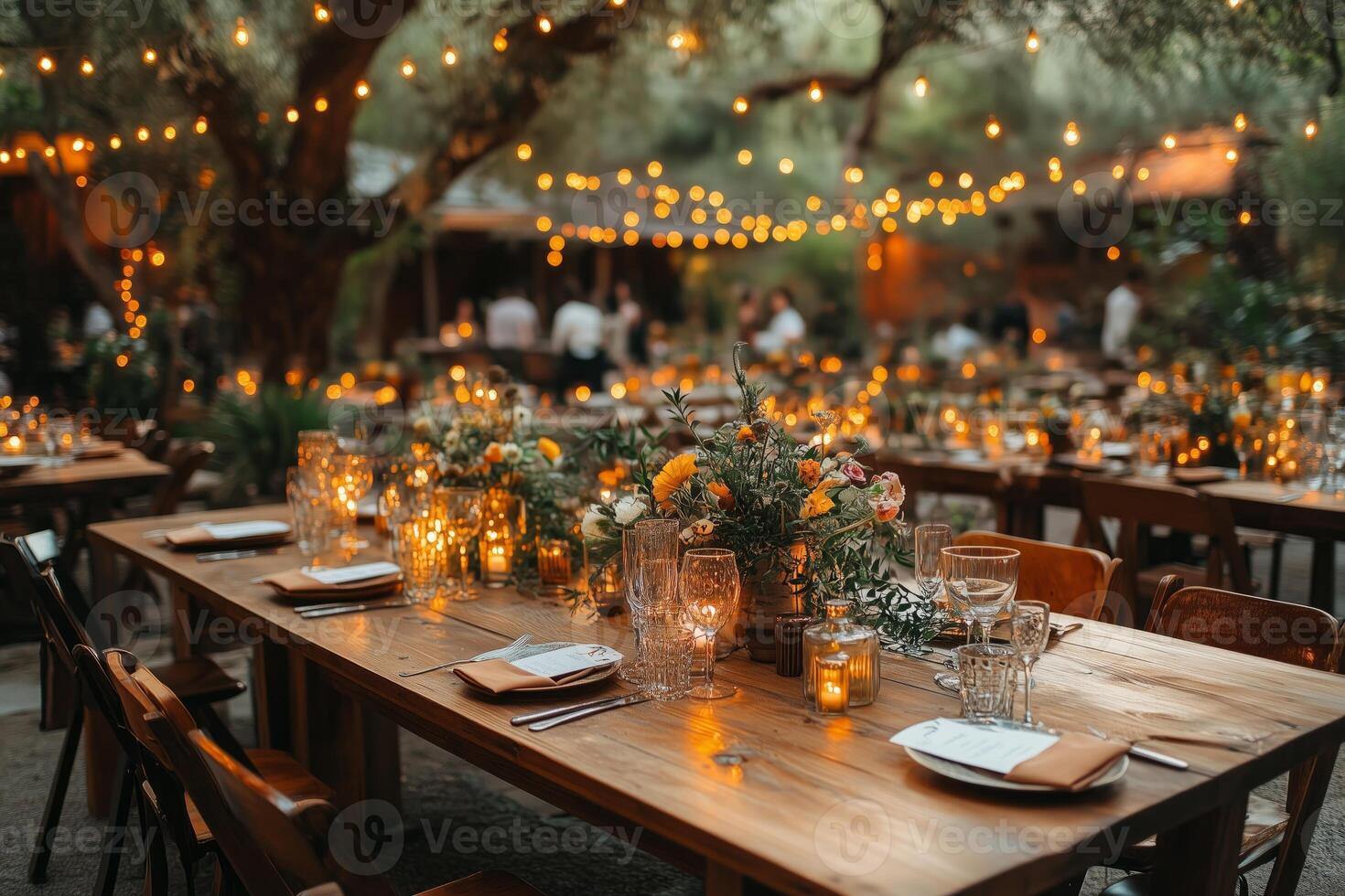 a boho style wedding reception with wooden tables, mismatched vintage chairs, and earthy toned table settings, surrounded by fairy lights and greenery, warm evening light photo