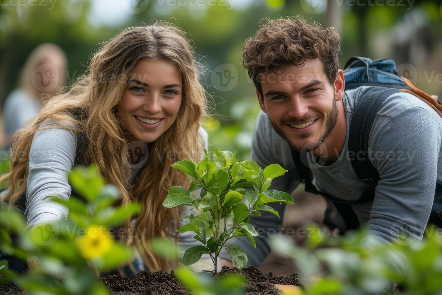 A young couple happily plants a tree together in their backyard, embracing an eco friendly lifestyle, surrounded by greenery photo