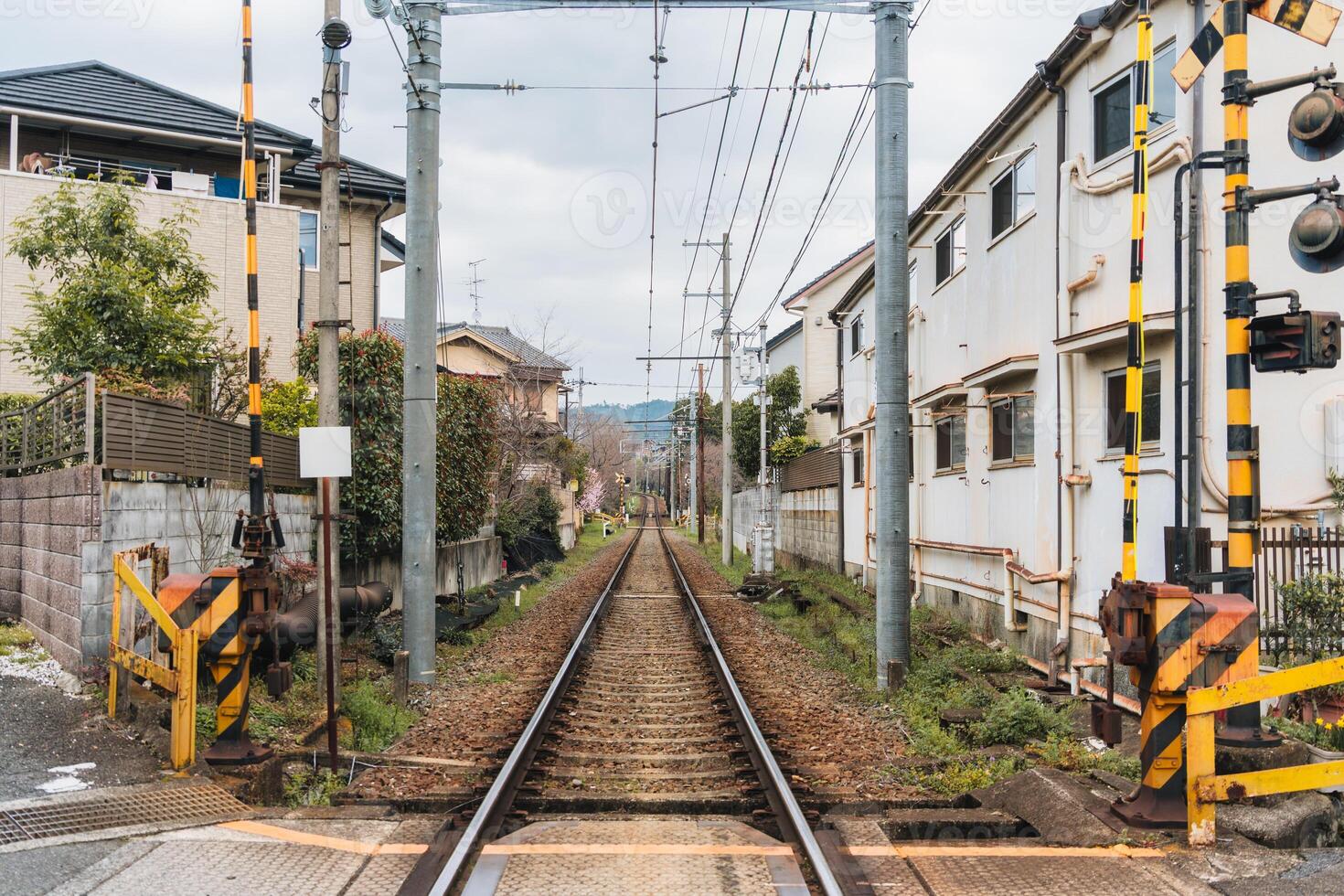 Railway with wire cable among community during springtime in suburban photo
