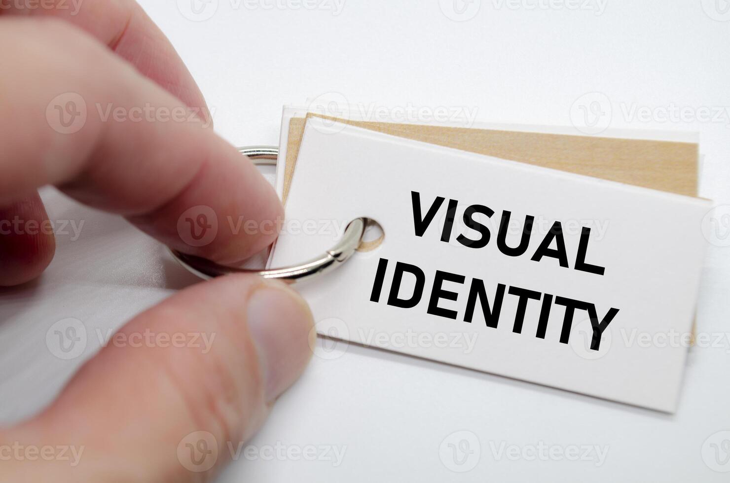 Visual identity concept presented on white notepad with hand holding it in clean workspace. photo