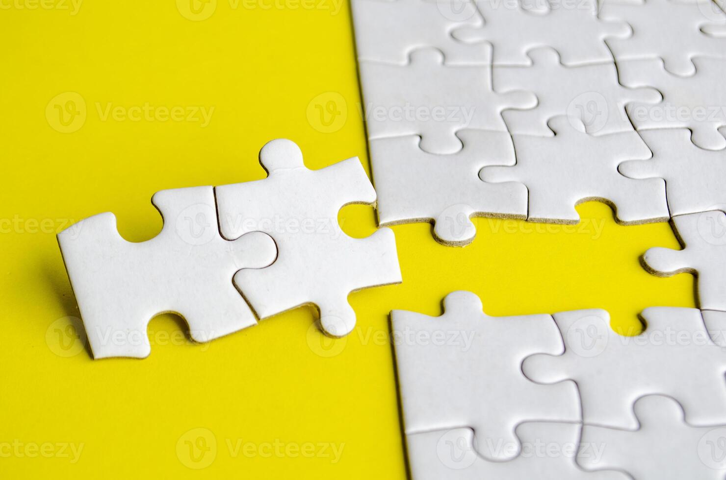 Close up view of missing white jigsaw puzzles, symbolizing partnership and unity on yellow background photo