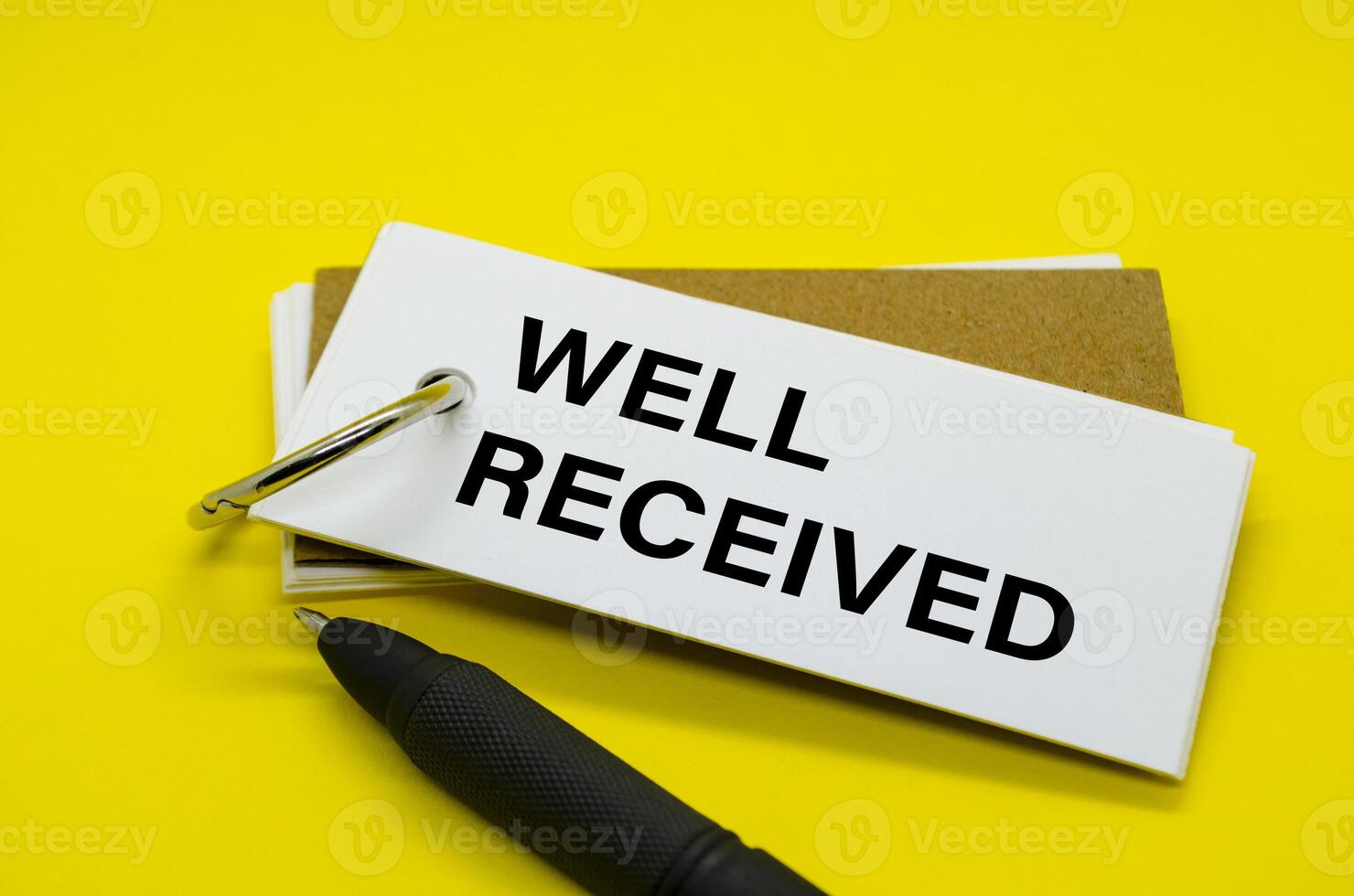Well Received Text on white notepad with yellow cover background. photo