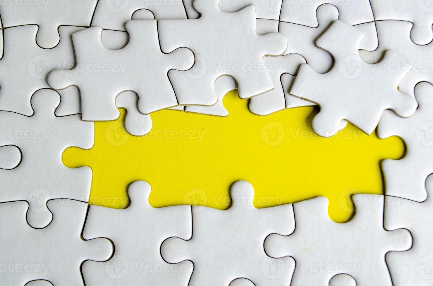 Symbol of partnership and unity shown through connected puzzle pieces on a vivid yellow background photo
