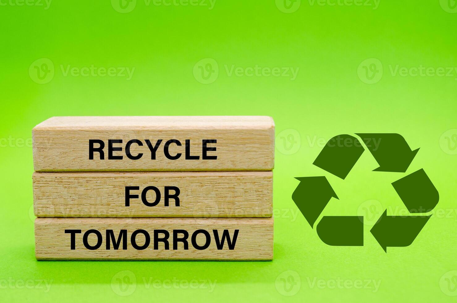 Recycle symbol with wooden blocks with text Recycle For Tomorrow on a green background. Promoting reuse, reduce, and recycle for sustainability. photo