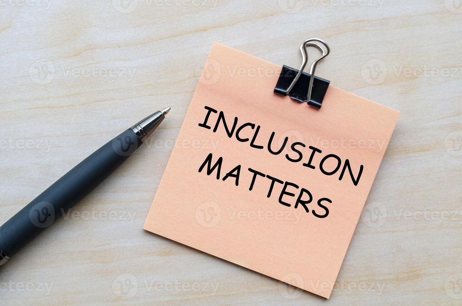 Inclusion matters text on pink notepad representing the importance of diversity and belonging in all spaces.. photo