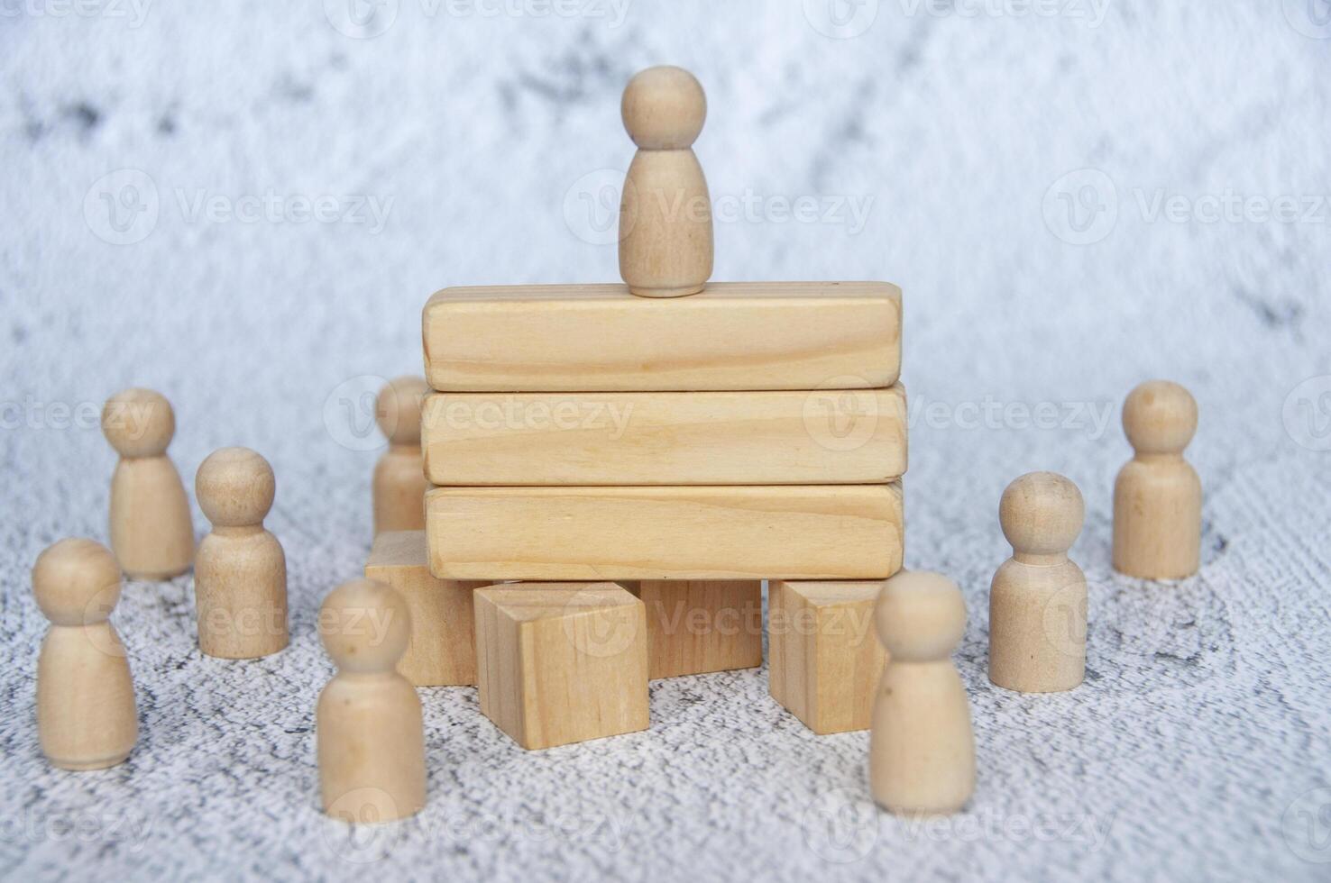 Wooden doll on to of wooden blocks with customizable space for text or ideas. Copy space and leadership concept photo