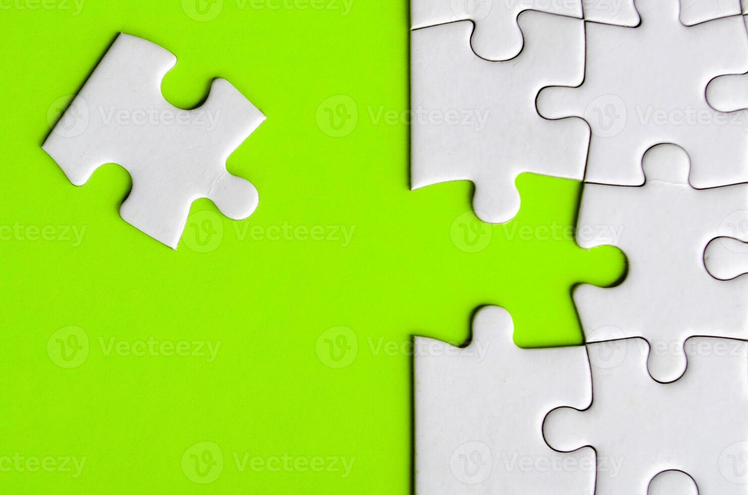 Connecting missing white jigsaw puzzle symbolizes partnership and unity on green background photo
