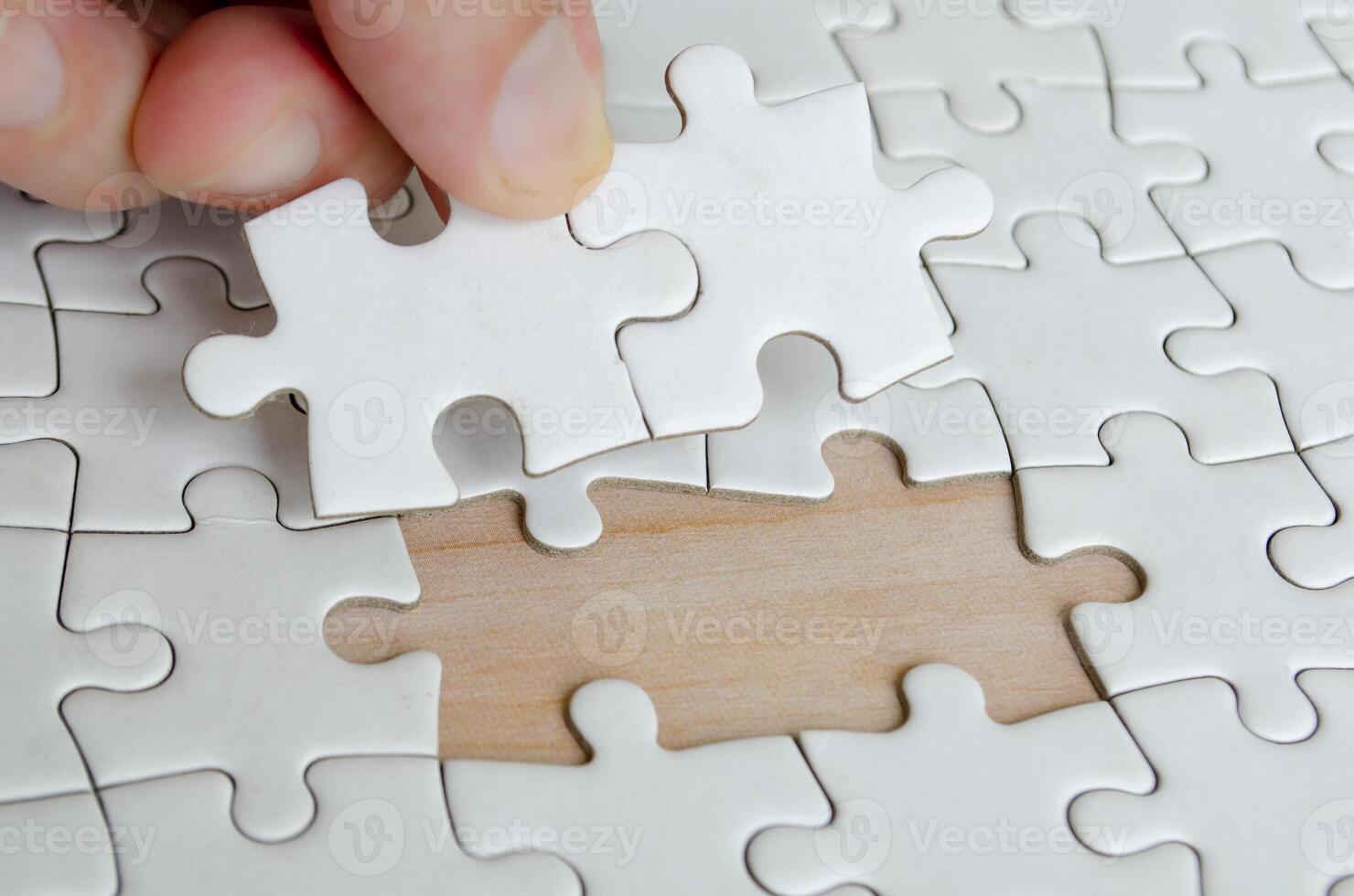 Hand placing missing jigsaw puzzle pieces. Solution concept photo
